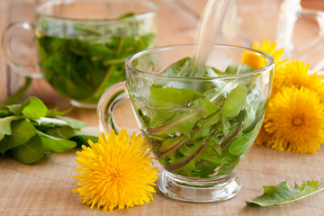 Obraz na płótnie Canvas Preparing dandelion tea by pouring hot water over fresh dandelion leaves