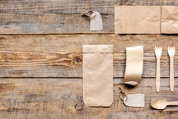 food delivery with paper bags and flatware on wooden table background top view mockup