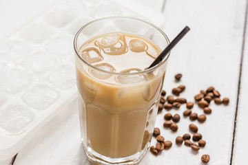 cold coffee glass with ice cubes on white table background