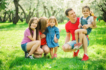 Fototapeta premium big family with three little daughters spending time together in summer park, mother, father and sisters having fun outdoor