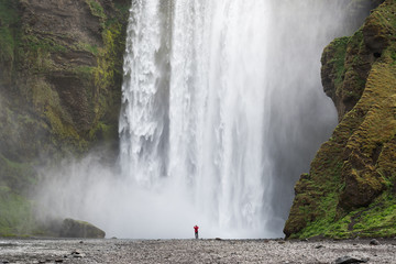 Tourist near a Skogafoss waterfall in Iceland