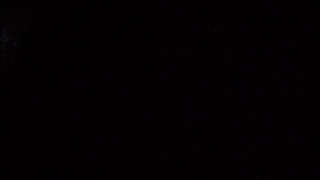 Some dust of liquid particles flowing on dark background