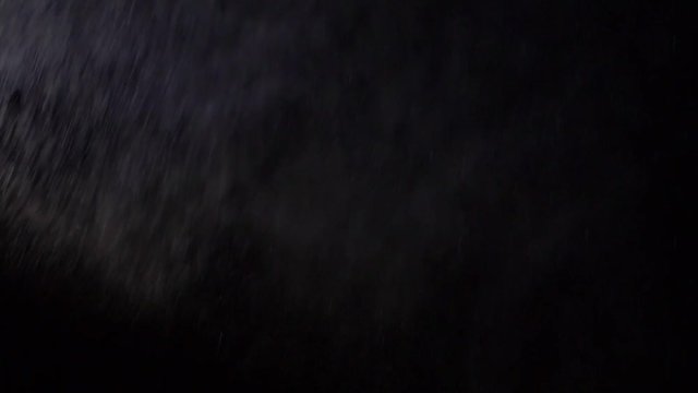 Some dust of liquid particles flowing on dark background