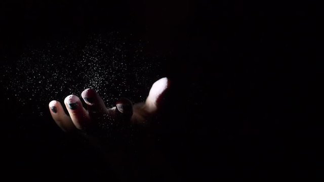 Slow motion of hands with chalk or dust splash