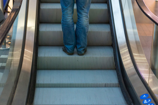 Girl wear sneaker riding on an escalator. feet standing on escalator - Powered by Adobe