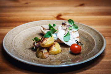 Grilled fish with roasted potatoes and vegetables on the plate
