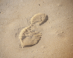 Fototapeta na wymiar human footprints in sand on beach at sunny day