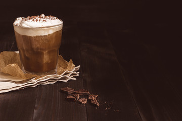 Ice coffee drink with chocolate on the wooden table, with copy space