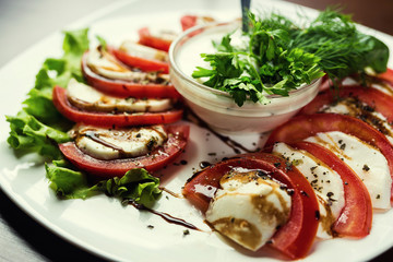 Delicious caprese salad with ripe tomatoes and mozzarella cheese with fresh basil leaves. Italian food.Italian salad, Caprese salad.Plate of Healthy Classic Caprese Salad