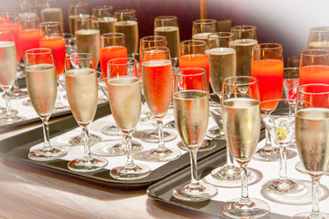 Row of glasses filled with champagne lined up ready to be served