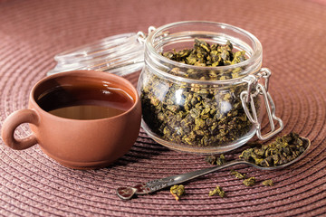 Dry leaves of green tea in a glass jar