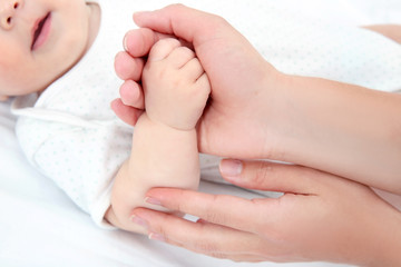 Fototapeta na wymiar Mother holding baby hand, closeup