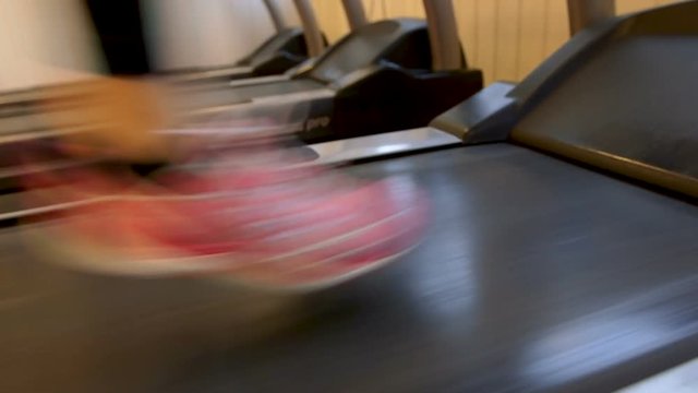 A woman doing fitness at a gym, running side