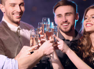 Friends clinking glasses of champagne at party in night club