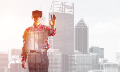 Fototapeta premium Guy wearing checked shirt and virtual mask stretching hand to touch something