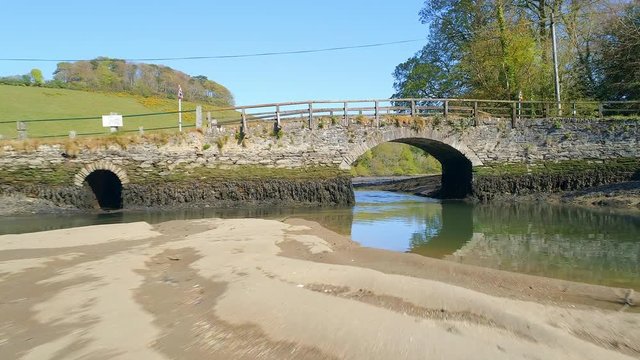 Flying Under an Old Stone Bridge in an Estuary in Cornwall, England