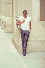 Young African American man carrying shoulder bag, traveling in New York