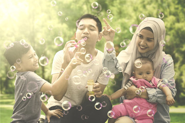Muslim family playing with soap bubbles