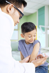 Pediatrician giving vaccine to his patient