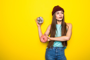 Happy stylish woman with donutes isolated on yellow background.