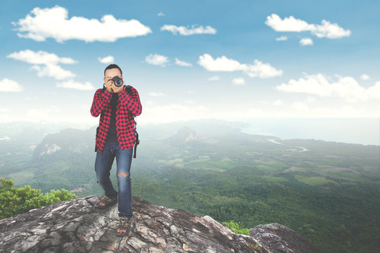 Young man taking photo on mountain