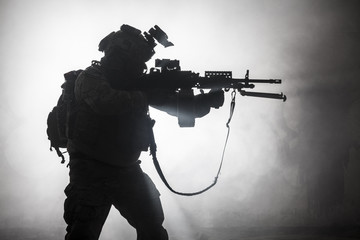 Black silhouettes of soldier in the smoke fire burning moving in battle operation. Back light