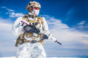 Army serviceman in winter camo somewhere in the Arctic. He wears chest rig and huge backpack,...