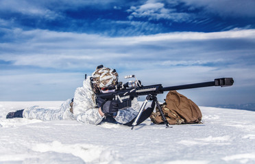 Army soldier with Sniper rifle in action in the Arctic. He lies in the snow desert, suffering from...
