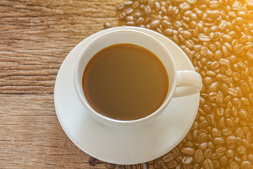 Coffee cup and coffee beans on old wood background