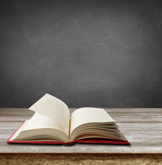 Book on table in front of blackboard