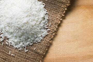 Jasmine rice in sack on wood table,top view