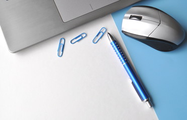 Laptop computer with a mouse, pen, office supplies on a table with copy space, top view, flat layout - a work from home workstation of a freelance