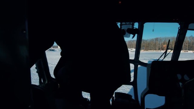 The pilot of the helicopter enters the cabin