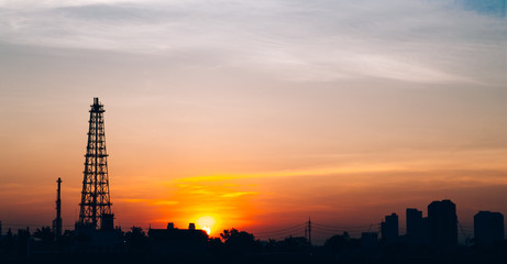 Fototapeta premium Oil refinery factory and logistic over sunrise Bangkok Thailand, with silhouette, Industrial zone, The equipment of oil refining, industrial pipelines of an oil-refinery plant, copy space.