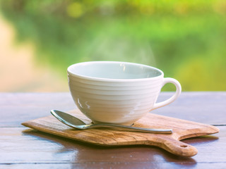 Hot coffee on wooden saucer and on wooden table
