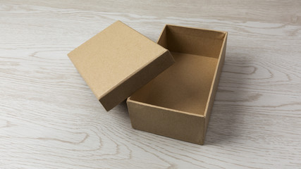 Uncovered Cardboard plain Box on white wooden Background