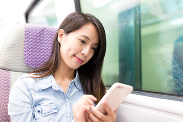 Woman using cellphone and taking the train
