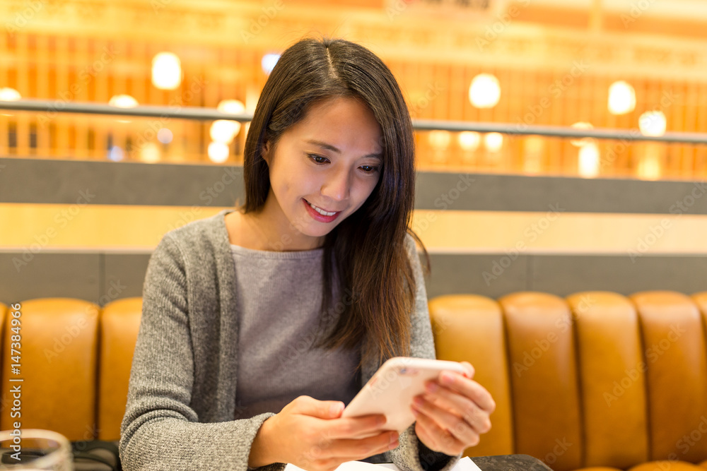 Canvas Prints Woman using cellphone in restaurant