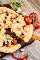 Photo of a hot pizza on wooden background.