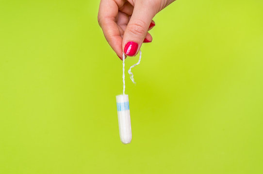 Woman holding menstruation tampon in hand