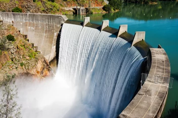 Fotobehang Dam Water stroomt over de top van de Englebright-dam in de Yuba-rivier. Een groter dan normaal sneeuwpakket in de Sierra Nevada Mountains heeft de afvoer naar meren en rivieren in Californië vergroot.