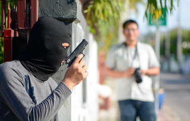 Male thief with pistol trying to steal tourist, Thief robber