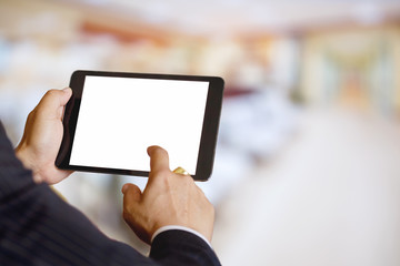 Businessman holding and touching digital tablet with blur patient at hospital background bokeh light, White screen mock up template for graphic display montage.