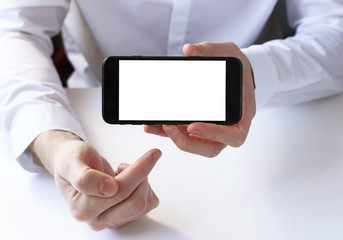 smart phone in hand on the background of working business environment