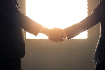 Business handshake and business people with silhouette