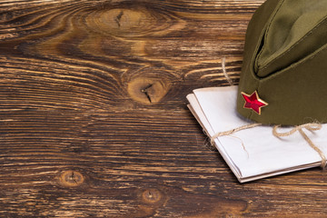 stack of old letters under the military cap on the table, place the graphic to the left
