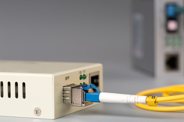 Two media converters connected by fiber cable - obrazy, fototapety, plakaty