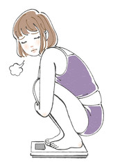 体重計に乗って落ち込む女性