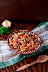 Pilaf on the brown plate on a wooden table, background. Rustic style.