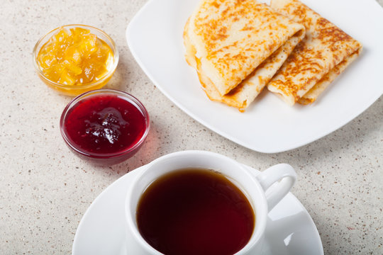 Cup of tea with jam, sour cream and russian pancakes - blini